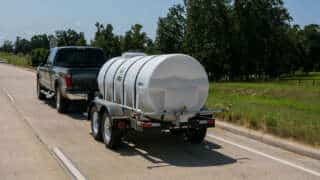 Truck Hauling 1000 Gallon Water Trailer On A Road
