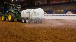 Tractor Pulling 1600 Water Trailer In A Horse Arena