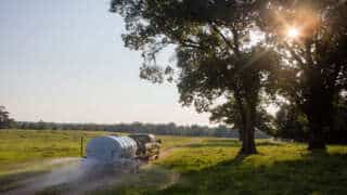 Truck Pulling 1600 D.O.T. Water Trailer On A Long Dirt Road