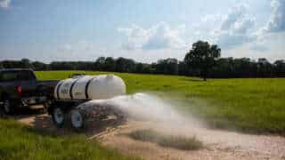 Truck 500 Gallon Water Trailer Spraying Dirt Road