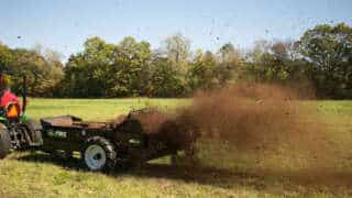 Tractor Pull behind 85 Ground drive manure spreader in pasture