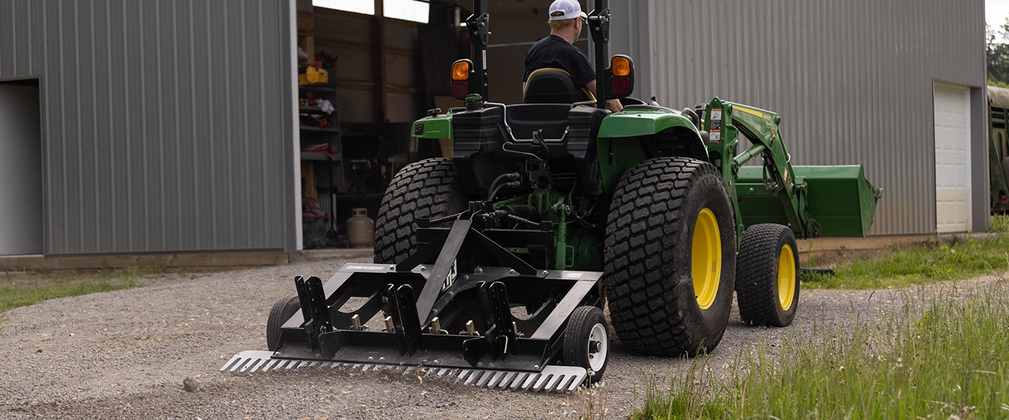 Tractor grating gravel driveway with back attachment