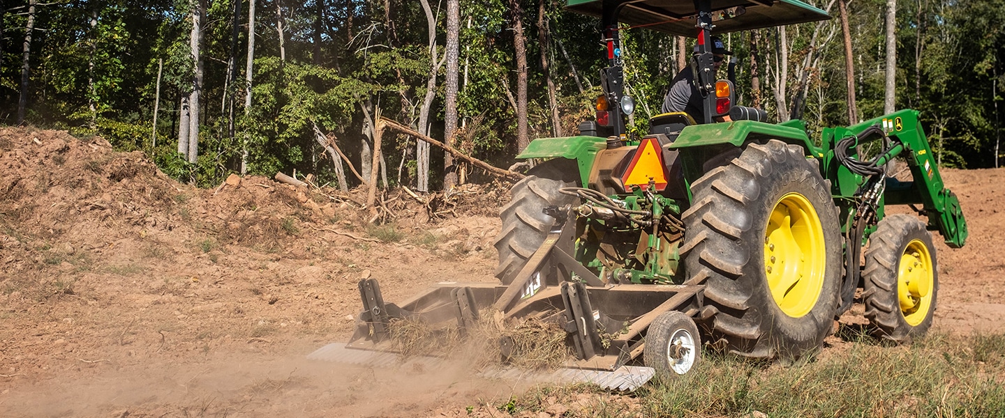 Tractor attachment pulling up vegetation