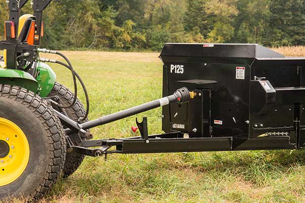 The PTO drive shaft of a 125ft³ PTO manure spreader attached to a tractor